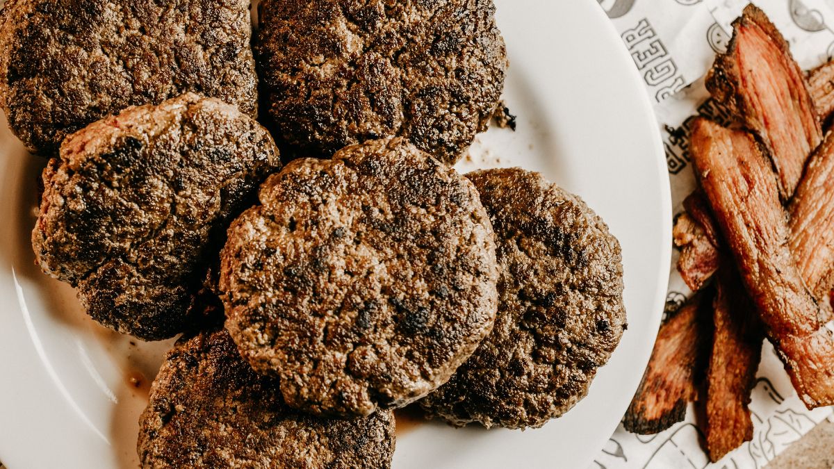 Overhead plate of seared beef smash patties with crisp, lacy edges