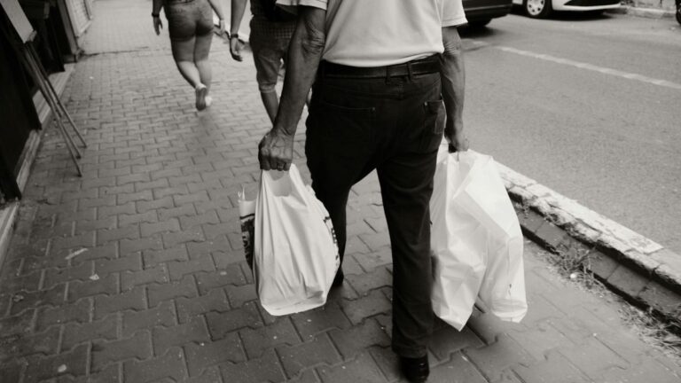Person hinging to pick up a small bag with neutral spine and soft jaw.