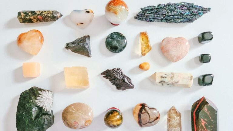 Various polished crystals arranged in neat rows on a white background