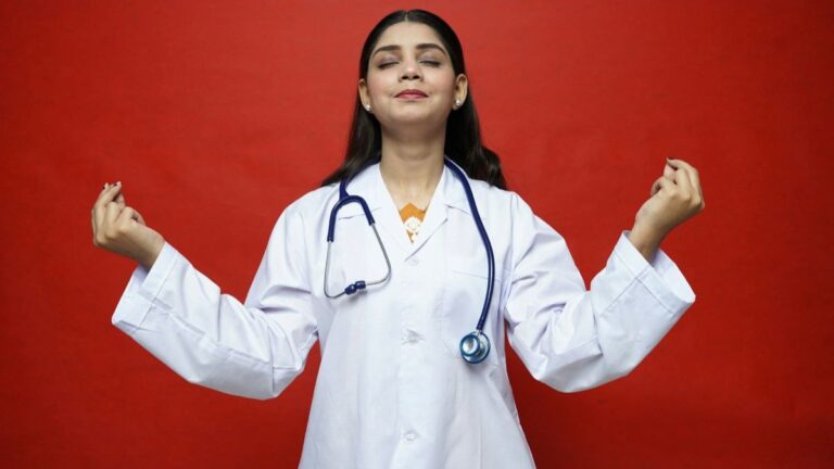 Clinician in a white coat with a stethoscope, eyes closed, meditating against a red background