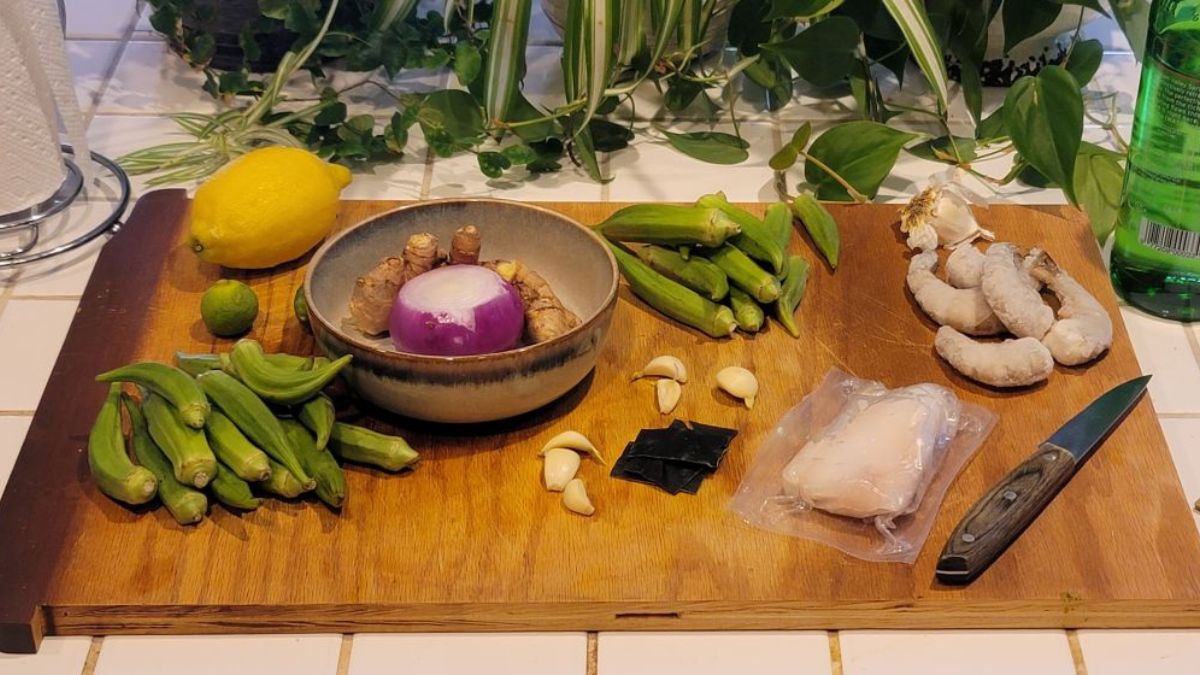 Bowl of okra chicken and cod mineral soup with shrimp, herbs, and rich broth