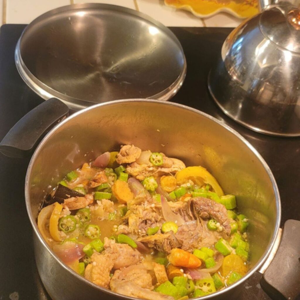Close view of okra chicken and cod soup with shrimp and savory broth