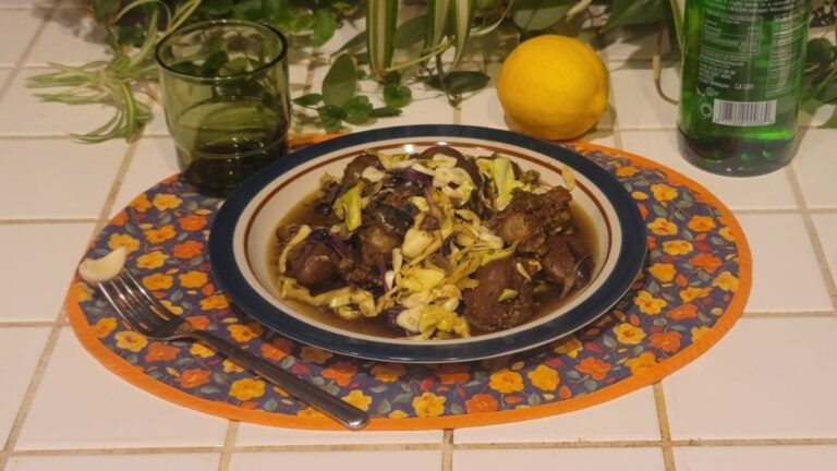 Slow-cooked oxtail and kidney bowl with red and green cabbage, garlic, and lemon on a kitchen counter