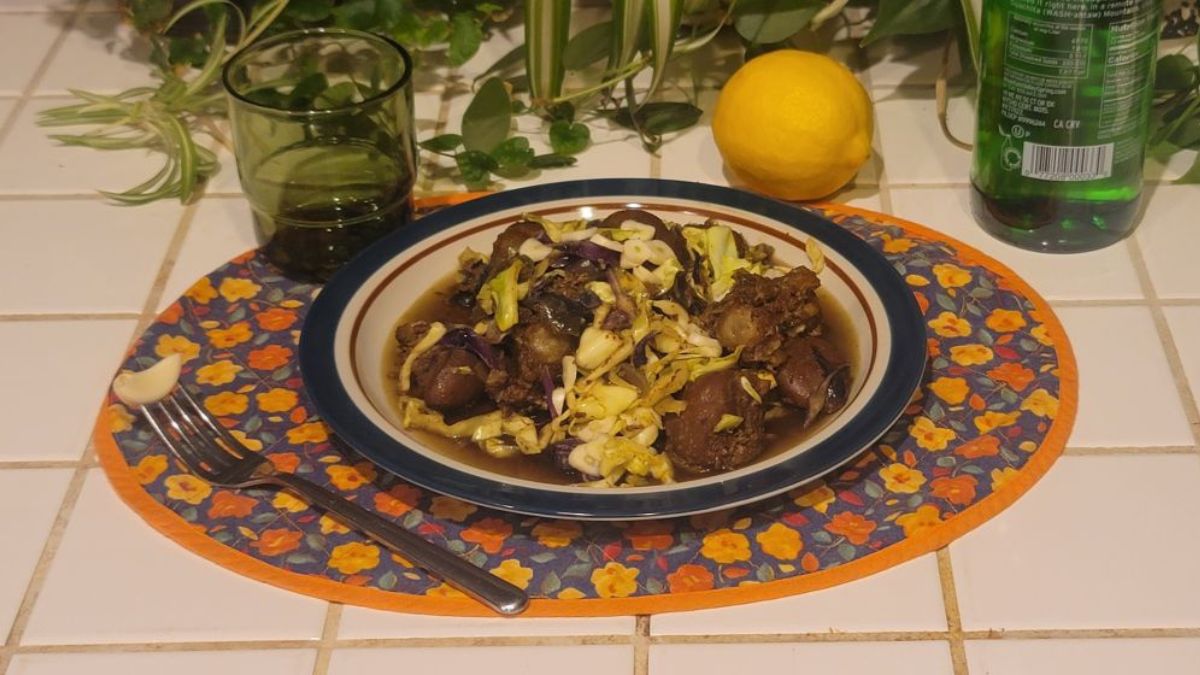 Slow-cooked oxtail and kidney bowl with red and green cabbage, garlic, and lemon on a kitchen counter